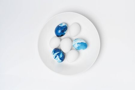 blue marble and white eggs in bowlの写真素材