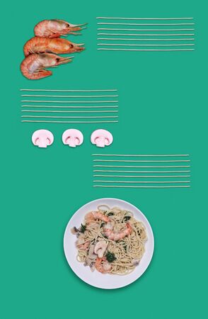 Pasta in the plate with ingredients mushrooms and shrimps and spaghetti on green backgroundの写真素材