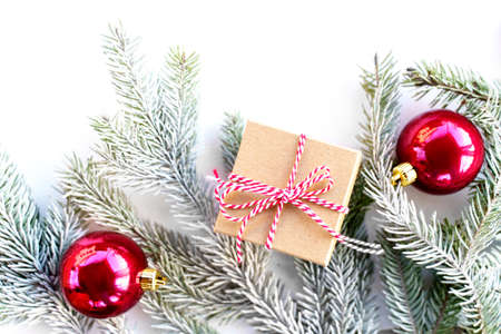 Flat lay new year cristmas pine tree, gift box and red balls on white