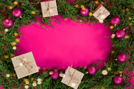 Flat lay new year cristmas craft boxes, pink magenta balls and pine tree on pinkの写真素材