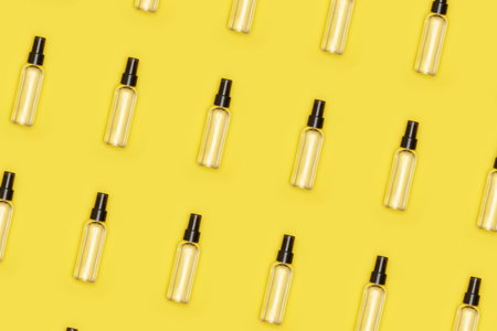 transparent cosmetic or antiseptic bottle on yellow isolated background pattern. High quality photo
