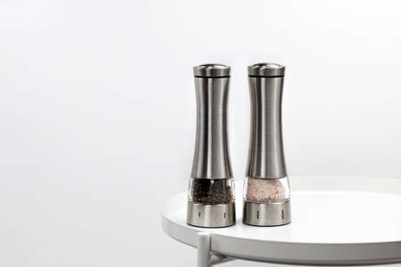Two electric spice mills for salt and pepper. Metal. On a white table. close upの写真素材