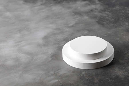 Two Podiums. White round podiums for presentation. Pedestals on gray background. Two round podiums.