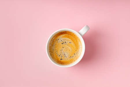 One coffee cup with Cappuccino on pink background. Espresso, ristretto drink with foam. top view, copy spaceの写真素材