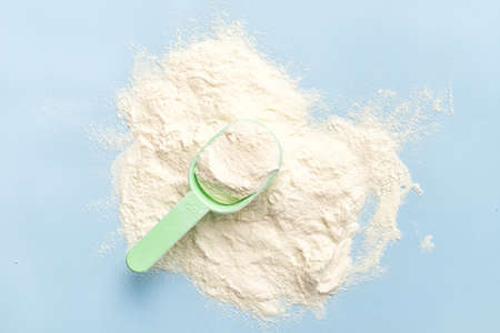 Ð¡ollagen powder in measure spoon on blue background. Supplement for skin care. top view, copy...