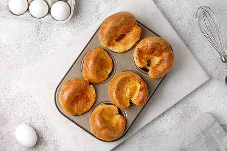 Traditional English Yorkshire pudding in baking dish, in muffin cups. Homemade British food. gray...