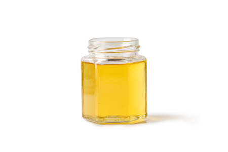 Open glass jar of honey isolated on a white background.の写真素材
