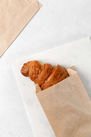 Croissant in a paper bag mock up, take away food. Brown envelope paper for food. Copy space for text.の写真素材