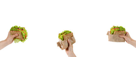 Banner with Sandwiches, snacks. Toasts with fresh lettuce, tomatoes and sausage in woman hands. Eating Healthy snack, take away food. Copy space, text.の写真素材