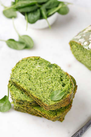 Spinach cake with Flaked almonds cutted on marble board. Pieces of Sponge green pie. gray background. green cake textureの写真素材