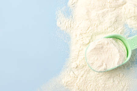 Ð¡ollagen powder in measure spoon on blue background. Supplement for skin care. top view, copy spaceの写真素材