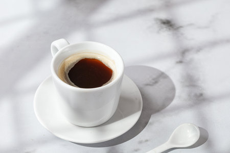 Cup with Coffee, hot drink in a mug. Mmarble background with window shadow. Sunny, sunshine. Arabica in coffee cup. copy spaceの写真素材
