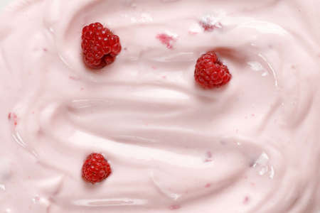 Pink Yogurt with raspberries. Curl of Yogurt. Pink nature yogurt, sour cream, ice cream. Delicious...