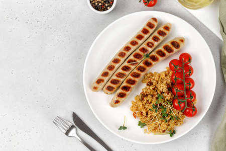 Dish with Barbecue chicken sausages, bulgur, tomatoes cherry and microgreen. Keto diet, heathy food, dinner idea. top view.の写真素材