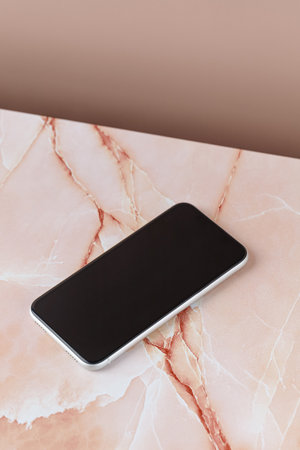 Phone mock up, Cellphone with blank screen, mobile phone, smartphone mockup, device is on beige pink marble background.の写真素材