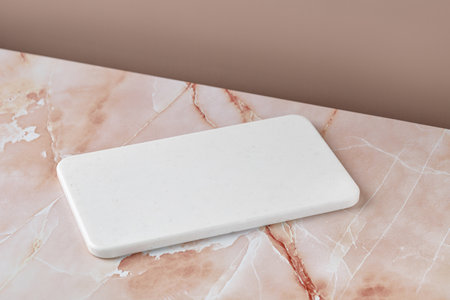 Empty blank white cutting board on beige pink marble background. Minimalist mockup for product...