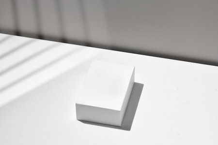 White empty podium on white table, background, display. Blank, gray wall. Template for advertising,...