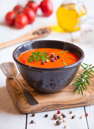Delicious tomato soup in a bowl on white woodの写真素材