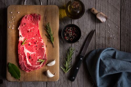 Raw reef meat, uncooked steak with rosemary, lemon and spices, ready to cookの写真素材