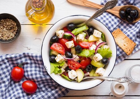 Delicious greek salad with feta cheese and olives in a white bowlの写真素材