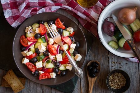 Delicious greek salad with feta cheese and olives in a brown plateの写真素材