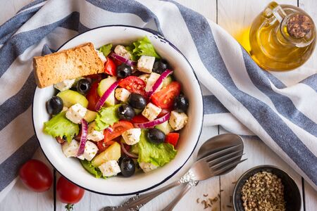 Delicious greek salad with feta cheese and olives in a white bowlの写真素材
