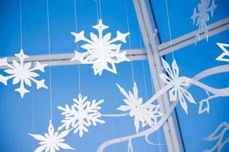 Winter snowflakes festive decoration against blue skyの写真素材