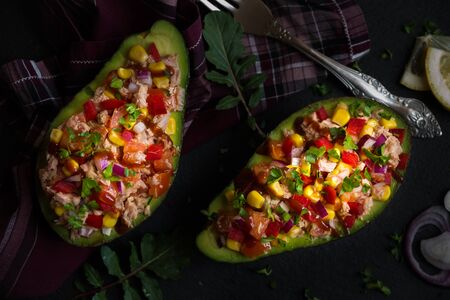 Avocado halves stuffed with tuna fish and vegetablesの写真素材