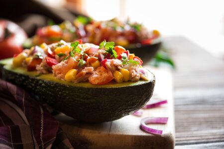 Avocado halves stuffed with tuna fish and vegetablesの写真素材