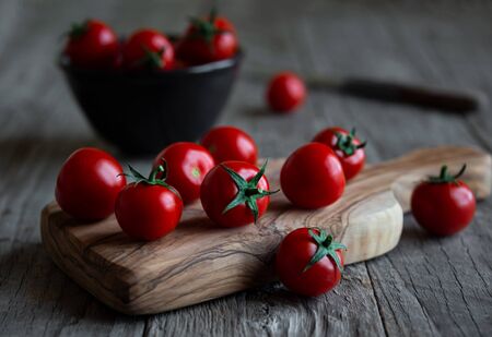 Fresh ripe organic cherry tomatoes on dark wooden backgroundの写真素材