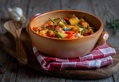 Chopped cooked vegetables on dark wood. ratatouille with zucchini, bell pepper and eggplantの写真素材