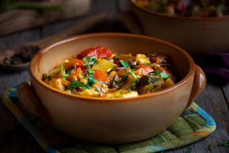 Chopped cooked vegetables on dark wood. ratatouille with zucchini, bell pepper and eggplantの写真素材