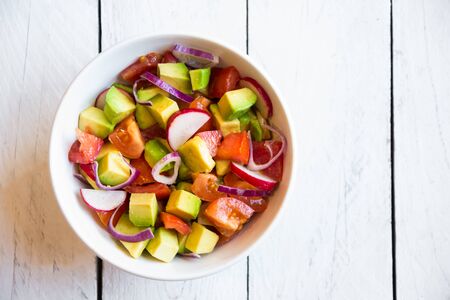 Fresh vegetable salad with avocado, tomatoes and radish. Healthy food conceptの写真素材
