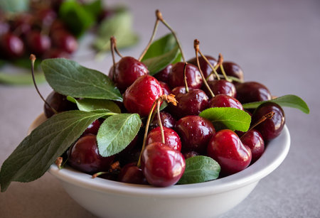 Fresh ripe dark cherry fruit with green leaves
