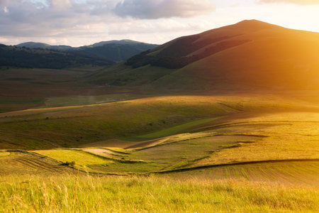 Hills and farm lands on sunsetの写真素材