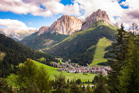 Dolomite alps with a mountain village and green meadowsの写真素材
