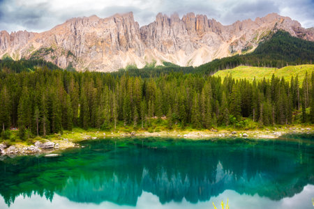 Carezza lake surrounded by forest and mountains in Dolomite alps, Italy
