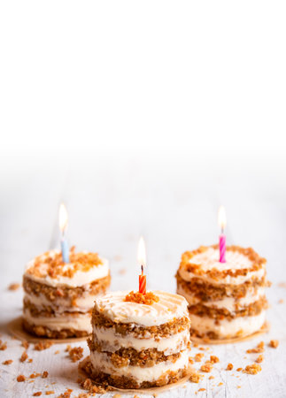 Small cakes with candles on white backgroundの写真素材