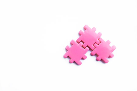 Three pink puzzle pieces perfectly connected, forming a seamless unity on a clean white background