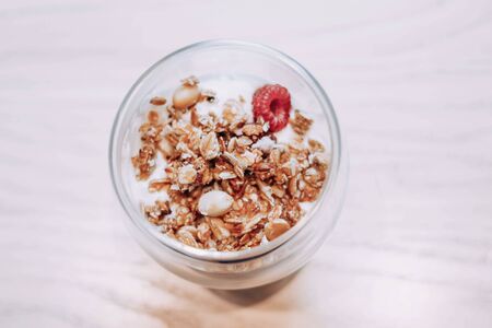 Muesli in a glass. Dessert in a cup and on a light background in cold shades. Diet breakfast. Diet food.の写真素材