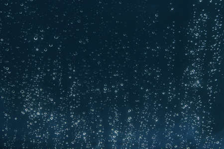 drops on glass on a dark background. dark background with the image of drops on the glass