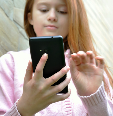 A girl is taking the selfy with a smartphoneの写真素材