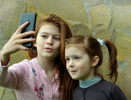 Two girls are taking the selfy with a smartphoneの写真素材