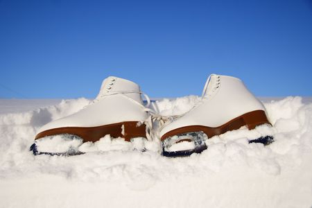 Closeup of figure skating ice skates lying in the snow outdoorsの写真素材
