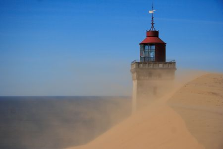 Lighthouse in the sand dunes of Rubjerg Knude in Denmarkの写真素材