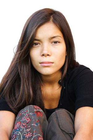 Beautiful serious young mixed race woman sitting. Isolated on white background.の写真素材