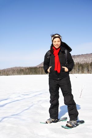 Woman winter hiking with snowshoes on frozen lake in Quebec, Canada.の写真素材