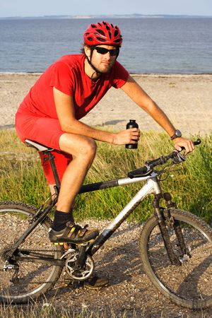 young man taking a break after extreme bikingの写真素材
