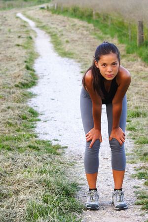Workout. Woman resting of running outside. Beautiful mixed race young woman.の写真素材