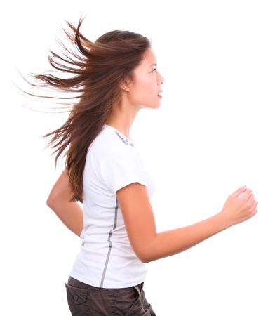 Isolated girl running with hair flying in the wind. Studio shot.の写真素材